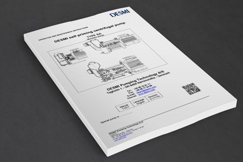 DESMI self-priming centrifugal pump manual, Type SA, on a gray surface.